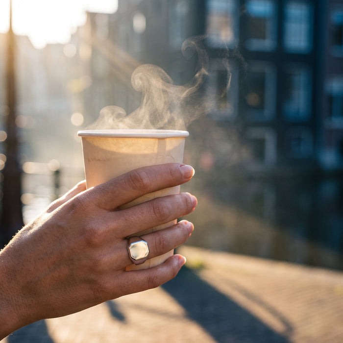 Imperium zegelring gedragen, hand om warme koffiebeker in ochtendlicht